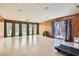 Spacious living room with wood paneling, tile floors, and sliding glass doors to the pool area at 7898 Wishing Well Rd, Las Vegas, NV 89123