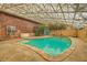 Indoor pool area with glass enclosure and brick accents, offering a private swimming experience at 7898 Wishing Well Rd, Las Vegas, NV 89123