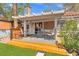 This cozy backyard shows a covered patio and an artificial lawn with stone steps leading into the yard at 8509 Lansdale Rd, Las Vegas, NV 89123