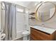 Bathroom featuring a shower-tub combo, stylish vanity, and circular mirror at 8509 Lansdale Rd, Las Vegas, NV 89123