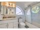 Bathroom featuring a vanity with granite countertop and shower-over-tub combo with unique circular window at 8713 Nautical Bay Ln, Las Vegas, NV 89117