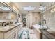 Bright bathroom with a skylight, double vanity, a tub, and a glass-enclosed shower at 8713 Nautical Bay Ln, Las Vegas, NV 89117