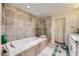 Luxurious bathroom featuring a soaking tub, glass shower, and elegant tile work at 8713 Nautical Bay Ln, Las Vegas, NV 89117
