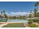 Picturesque lake view showcasing waterfront homes, palm trees, and mountain backdrop at 8713 Nautical Bay Ln, Las Vegas, NV 89117