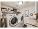 Functional laundry room with modern appliances, granite countertop, and ample storage space at 8713 Nautical Bay Ln, Las Vegas, NV 89117
