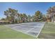 Well-maintained tennis court surrounded by mature trees and fencing at 8713 Nautical Bay Ln, Las Vegas, NV 89117