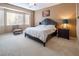 Cozy main bedroom with neutral walls, plush carpet, and large windows at 9077 Creed Mountain Pl, Las Vegas, NV 89178