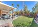 Lush backyard featuring a covered patio, pool, and artificial lawn, perfect for outdoor gatherings at 10654 Sidlaw Hills Ct, Las Vegas, NV 89141