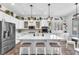 Bright kitchen featuring white cabinets, a marble island with seating, and stainless steel appliances at 10654 Sidlaw Hills Ct, Las Vegas, NV 89141