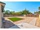 Large, sand-filled backyard with artificial turf, a patio, and a wooden fence, perfect for outdoor activities and landscaping at 1411 Norman Ave, Las Vegas, NV 89104