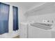 Bright laundry room featuring a washer, dryer, blue curtains and an overhead shelf at 1411 Norman Ave, Las Vegas, NV 89104