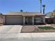 Charming single-story home featuring a well-manicured front yard and a two-car garage and tile roof at 1468 Harmony Hill Dr, Henderson, NV 89014