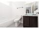 Bathroom featuring a vanity with vessel sink, tub, and white tile at 1609 Hills Of Red Dr # 104, Las Vegas, NV 89128