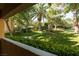 Serene view from patio showcases well-manicured lawn, mature trees, and landscaping at 1609 Hills Of Red Dr # 104, Las Vegas, NV 89128