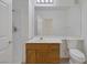 Bathroom featuring a shower, sink, wooden vanity, mirror, and toilet at 1830 N Buffalo Dr # 2024, Las Vegas, NV 89128
