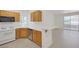 Well-equipped kitchen with natural wood cabinets, a breakfast bar, and a view of the living area at 1830 N Buffalo Dr # 2024, Las Vegas, NV 89128