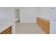 Open-concept living area with wood-look floors, storage cabinets, and kitchen access at 1830 N Buffalo Dr # 2024, Las Vegas, NV 89128