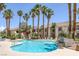 Community pool surrounded by palm trees, lounge chairs, and residential buildings on a clear day at 1830 N Buffalo Dr # 2024, Las Vegas, NV 89128