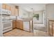 Kitchen view with wood cabinets and white appliances overlooking adjacent dining area at 2026 Wildwood Lake St, Henderson, NV 89052