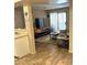 Inviting living room featuring wood flooring, a large TV, and sliding doors, creating a cozy and open living space at 2120 Ramrod Ave # 417, Henderson, NV 89014