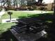 Community picnic area with a metal table and benches, and a barbecue grill in a grassy lawn at 2120 Ramrod Ave # 417, Henderson, NV 89014