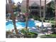 Community pool with palm trees, lush landscaping and patio furniture at 2120 Ramrod Ave # 417, Henderson, NV 89014
