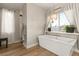 Bathroom featuring a soaking tub under a window with views, dark wood cabinets and modern fixtures at 258 Castellari Dr, Las Vegas, NV 89138