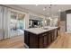 Open concept kitchen with dark wood cabinets, a large island, and a view into the living and dining spaces at 258 Castellari Dr, Las Vegas, NV 89138