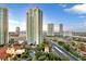 Striking aerial view of luxury high-rise condos, beautiful landscaping, and Las Vegas skyline against a blue sky at 2777 Paradise Rd # 1002, Las Vegas, NV 89109