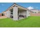 Beautiful backyard featuring a covered patio, artificial turf, and a well-maintained exterior at 3024 River Brook Ct, Las Vegas, NV 89139