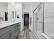 Modern bathroom featuring double sinks, sleek cabinetry, and a glass-enclosed shower at 3024 River Brook Ct, Las Vegas, NV 89139