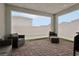 Enclosed covered patio with brick flooring, comfortable outdoor seating, and views of the surrounding neighborhood at 3024 River Brook Ct, Las Vegas, NV 89139