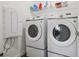 Well-equipped laundry room with Samsung washer and dryer, overhead shelving for supplies, and modern design at 3024 River Brook Ct, Las Vegas, NV 89139