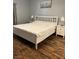 Bedroom with white framed bed, two end tables, and hardwood floors at 3320 S Fort Apache Rd # 139, Las Vegas, NV 89117