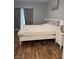 Bedroom with white framed bed, hardwood floors, two end tables, and neutral wall paint at 3320 S Fort Apache Rd # 139, Las Vegas, NV 89117