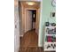 Hallway with hardwood floors leads to a well-lit bathroom with white cabinets and modern fixtures at 3320 S Fort Apache Rd # 139, Las Vegas, NV 89117