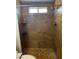 Updated tiled shower with brown tiling, decorative tile accents, and a convenient built-in shelf at 3320 S Fort Apache Rd # 139, Las Vegas, NV 89117