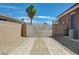 Gated gravel backyard with brick accents and a private entrance at 334 Cougar Estates Ln, Las Vegas, NV 89123