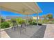 Relaxing covered patio with stone flooring, chaise lounges, a ceiling fan and lovely landscaping at 334 Cougar Estates Ln, Las Vegas, NV 89123