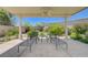 Well-lit covered patio featuring chaise lounges, a ceiling fan, and scenic backyard landscaping at 334 Cougar Estates Ln, Las Vegas, NV 89123