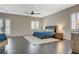 Bright main bedroom with a ceiling fan, hardwood floors, modern window shutters, and patio access at 334 Cougar Estates Ln, Las Vegas, NV 89123