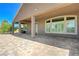 Spacious covered patio with stone pavers and views of the surrounding landscape at 334 Cougar Estates Ln, Las Vegas, NV 89123