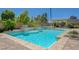 Beautiful pool with stone tile, landscaping, and shallow sunbathing areas at 334 Cougar Estates Ln, Las Vegas, NV 89123
