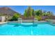 Sparkling pool with clear blue water, stone accents, and lush landscaping, creating a serene backyard oasis at 334 Cougar Estates Ln, Las Vegas, NV 89123