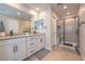 Well-lit bathroom with dual sinks, spacious countertop, and glass-enclosed shower at 3778 Via Gennaro, Henderson, NV 89044