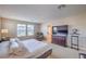 Bright bedroom with natural light features a large bed, dresser with TV, and cozy armchair at 3778 Via Gennaro, Henderson, NV 89044