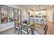 Bright dining area features a glass table, wood chairs, and views to the open-concept kitchen and reflected living area at 3778 Via Gennaro, Henderson, NV 89044