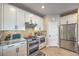 The modern kitchen features stainless steel appliances, granite countertops, backsplash, and a door to the garage at 3778 Via Gennaro, Henderson, NV 89044
