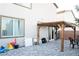 A backyard featuring a paved area with a wood pergola, sliding glass doors, and minimal landscaping at 4178 Eagle Island St, Las Vegas, NV 89130