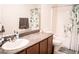Well-lit bathroom featuring granite countertops, vanity, and a shower with a leafy green decorative shower curtain at 4178 Eagle Island St, Las Vegas, NV 89130
